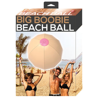 Bright pink Big Boobie Beach Ball by Hott Products, a fun novelty inflatable with exaggerated bust design, on a sunny beach.